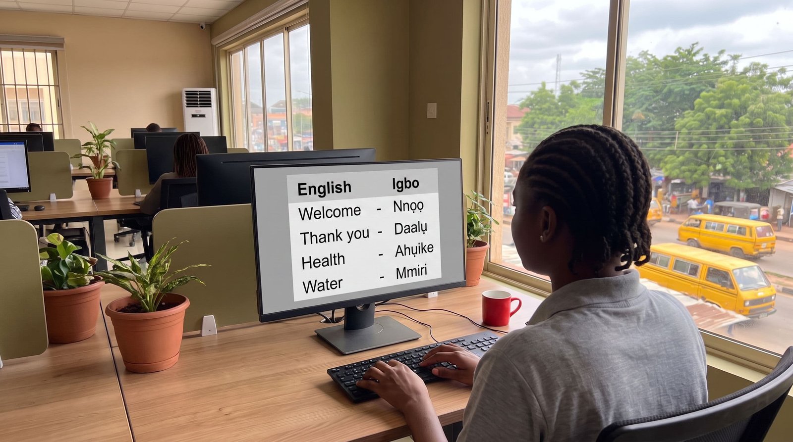 Igbo translation visual: Igbo language specialist reviewing multilingual work at a computer.