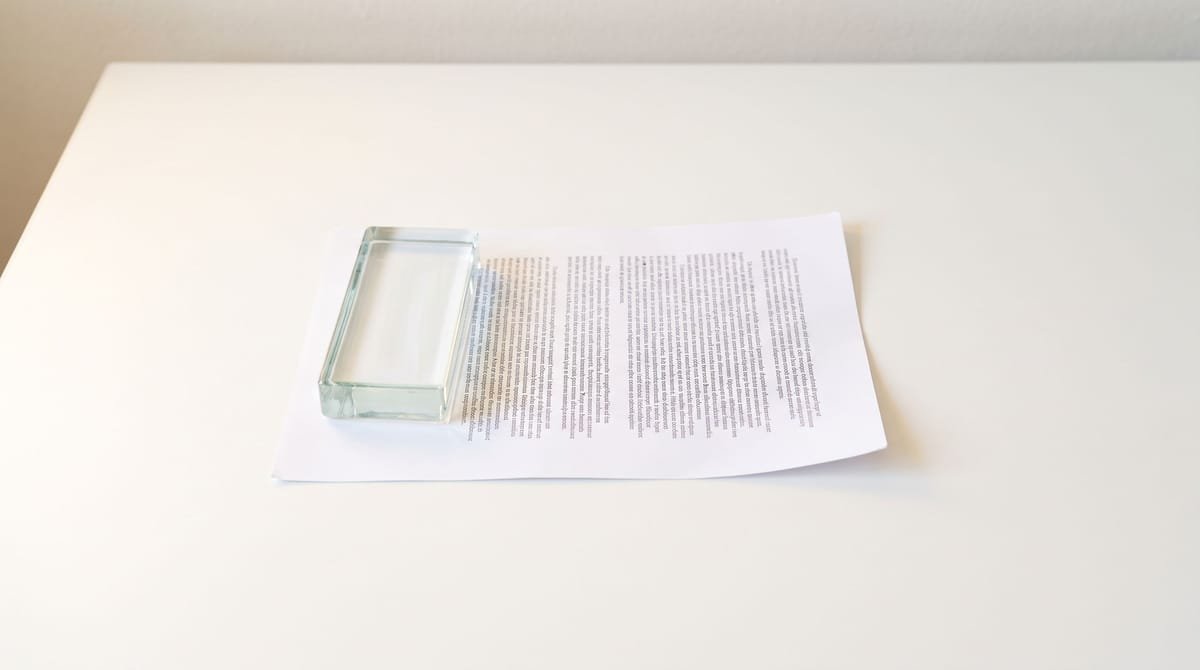 Luba-Katanga translation visual: A consent page lying face down beneath a plain paperweight.