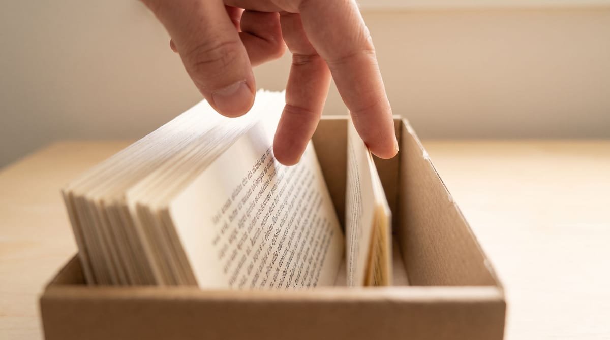 Quechua translation visual: Two fingers walking back through cards standing on edge in a box.
