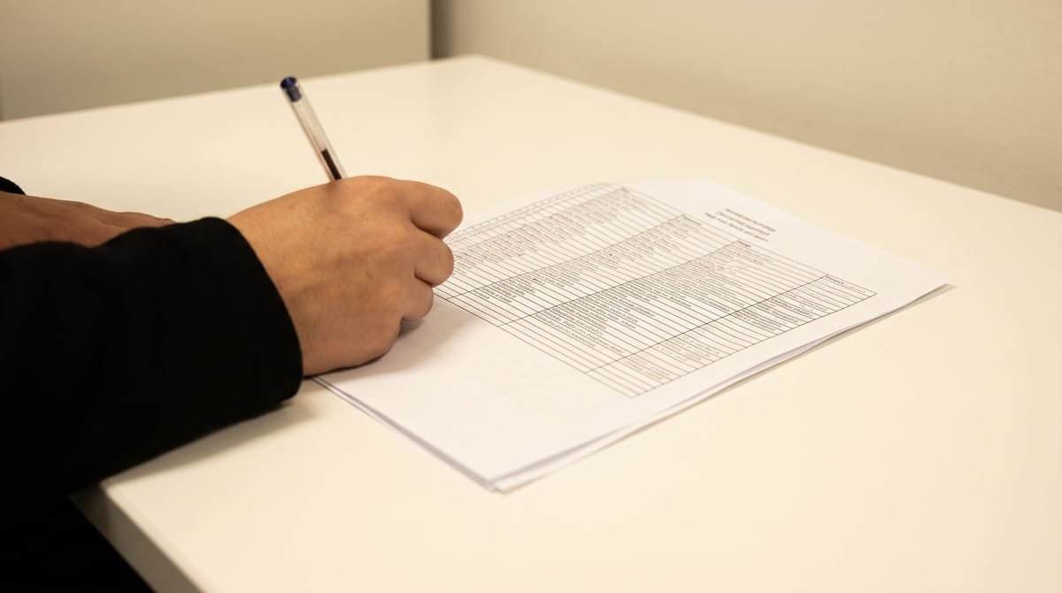 Zulu translation visual: A hand filling in the one blank row on a printed roster.